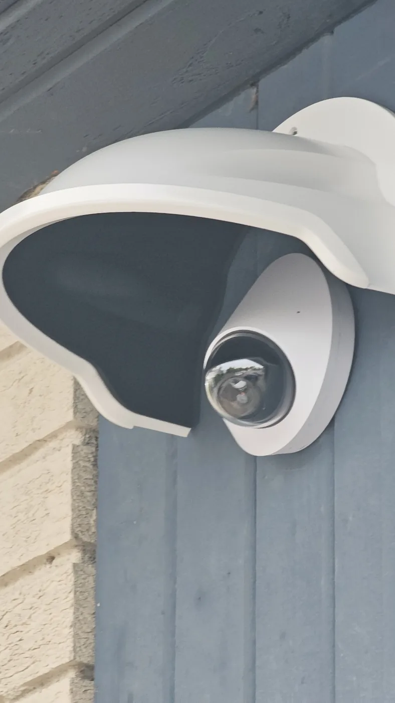 An outdoor dome camera on a wall bracket, sealed against the weather